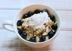 a bowl filled with oatmeal and blueberries on top of a table