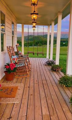 a porch with rocking chairs and flowers on it