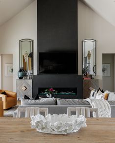 a living room filled with furniture and a fire place next to a tv mounted on a wall