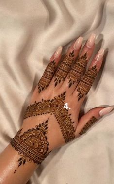 a woman's hand with henna tattoos on it