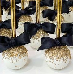 some white chocolates with gold sprinkles and a black bow on them