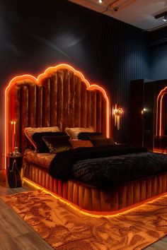 a large bed sitting inside of a bedroom next to a wall mounted mirror and two candles