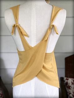 a mannequin with a yellow top on it's back and tie around the neck