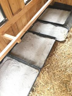 the inside of a horse trailer with hay and straw on the floor next to it