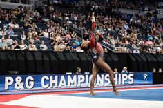 a woman doing a handstand in front of a crowd