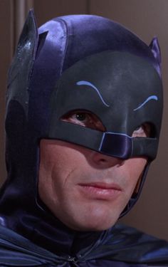 a man wearing a batman mask and looking at the camera