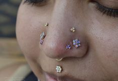 a close up of a woman's nose with piercings on her nose and nose