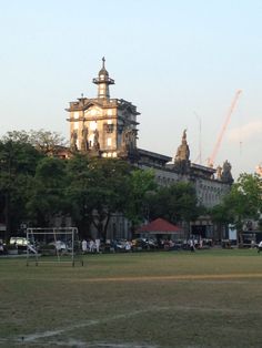 people are playing soccer on the field in front of an old building