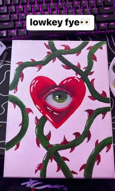 an eye peers into a heart - shaped painting on a computer keyboard, with the words low key above it