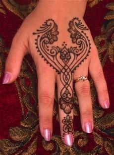 a woman's hand with henna tattoos on it