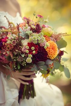 a woman holding a bouquet of flowers in her hands