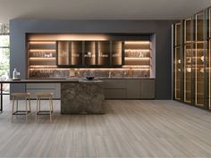 a modern kitchen with marble counter tops and bar stools