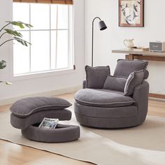 a living room with a chair and ottoman on the floor in front of a window