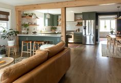 a living room filled with furniture next to a kitchen