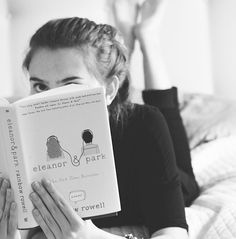 a woman laying in bed reading a book