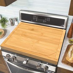 a stainless steel oven with wooden cutting board