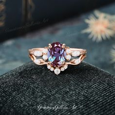 a ring with an oval shaped purple stone surrounded by small white and pink diamonds on top