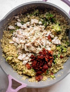 a pan filled with food on top of a white counter next to a pink spatula