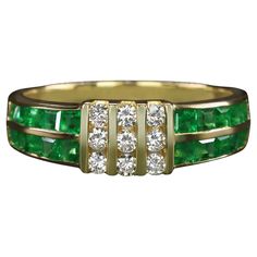 This emerald and diamond band offers a bold and luxurious design with rich pops of green punctuated by bright sparkle. Highlights: - 1.10ct of rich green natural emeralds - 0.25ct of white and eye clean diamonds - Chunky yellow gold channel settings Dimensions: The ring measures 5.9mm across (north to south) and 3.0mm from finger to top. Additional Notes: Due to the setting style, resizing is limited for this ring. It can be resized to a minimum of 4.25 and a maximum of 8.25 Green Emerald Diamond Ring With Pave Setting, Fine Jewelry Green Emerald Ring With Single Cut Diamonds, Luxury Green Rings With Single Cut Diamonds, Luxury Green Emerald Ring With Single Cut Diamonds, Green Emerald Ring With Diamond Accents, Green Diamond Ring With Single Cut Emerald Shape, Green Emerald Ring With Pave Setting, Green Emerald Cut Diamond Ring With Single Cut Diamonds, Emerald Pave Setting Ring For Anniversary