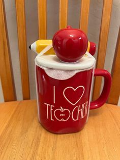 a red coffee mug with an apple on top and the words i love teachers written on it