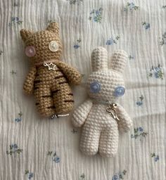 two crocheted stuffed animals laying on a bed