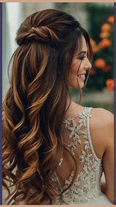 a woman with long, wavy hair wearing a wedding dress and smiling at the camera