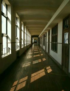 the sun shines through large windows in an empty building