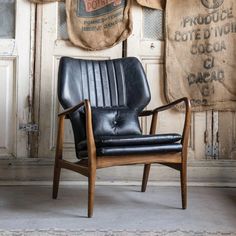 a black leather chair sitting in front of a wall with burlocks on it