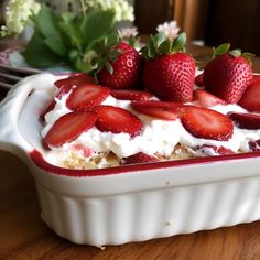 strawberries on top of whipped cream in a dish