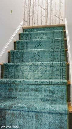 blue carpeted stairs leading up to a white wall