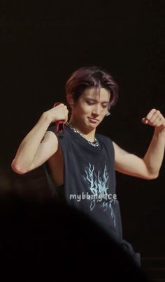 a young man is flexing his muscles in front of an audience at a concert