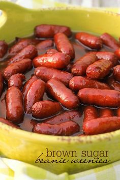 a yellow bowl filled with hot dogs on top of a table