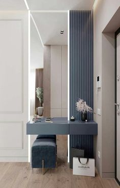 a blue vanity table in front of a white wall and wooden floor with a mirror on it