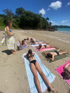 people are laying on towels at the beach