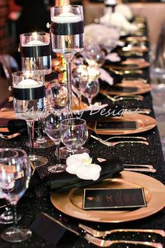 the table is set with black and gold place settings