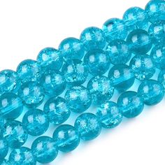 blue glass beads are lined up on a white surface