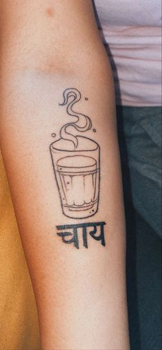 a person with a tattoo on their arm and the word coffee is written in it