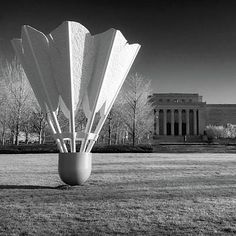 black and white photograph of sculptures in front of a building