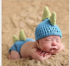 a baby wearing a crocheted hat and diaper laying on top of a blanket