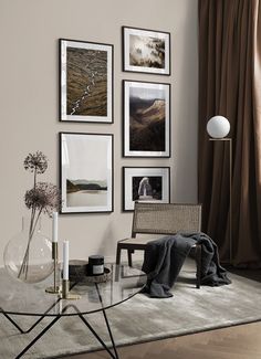 a living room with pictures on the wall and a glass table in front of it