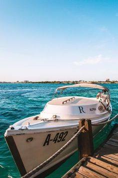 a boat is docked at the dock in the blue water, with another boat behind it