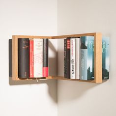 a book shelf with several books on it and a light hanging from the wall behind it