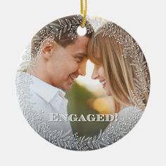 an ornament with the words engaged on it and a photo of two people