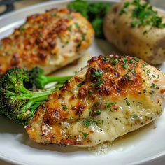 two pieces of chicken and broccoli on a white plate