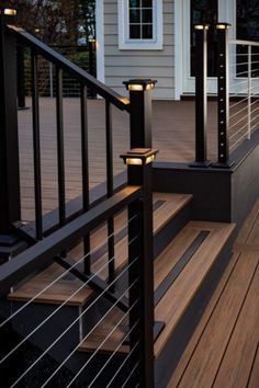 some lights are on the side of a wooden decking area with stairs and railings