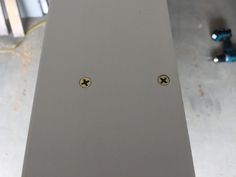 two small gold studs sitting on top of a metal table