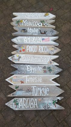 five surfboards are lined up on the ground with words written on them in different languages