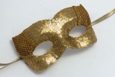 Gold sequin masquerade mask embellished with a sparkling lurex mesh and satin ribbons. Masquerade masks made by Maskaku are a product of love for beauty and handicrafts.  All products are unique and entirely hand-made. Masks can cover your face but you are still guaranteed to stand out wearing one of them. They are ideally suited for a masked ball, costume party or a wedding gift. Many designs come in pairs both for him and for her in similar colors but unique shapes.  I'm sure you will find the Ball Costume, Masked Ball, Masquerade Masks, Satin Ribbons, Unique Shapes, Carnival Masks, Decoration Originale, Masks Masquerade, Masquerade Mask