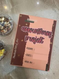 a book sitting on top of a table next to bowls filled with fruit and nuts