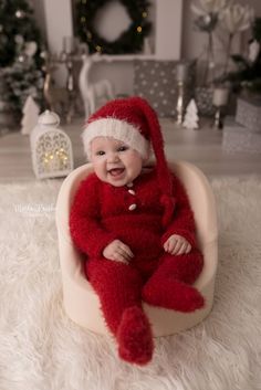 a baby wearing a santa hat and sitting in a chair